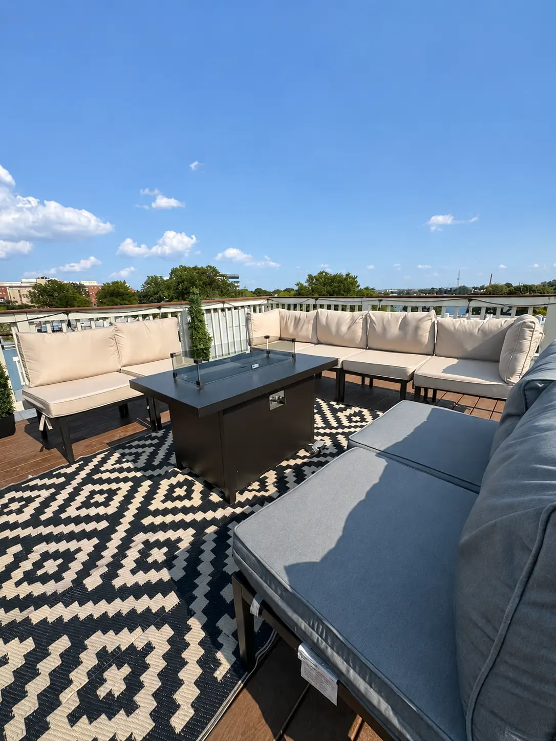 Furnished rooftop deck with patterned rug and sectional seating