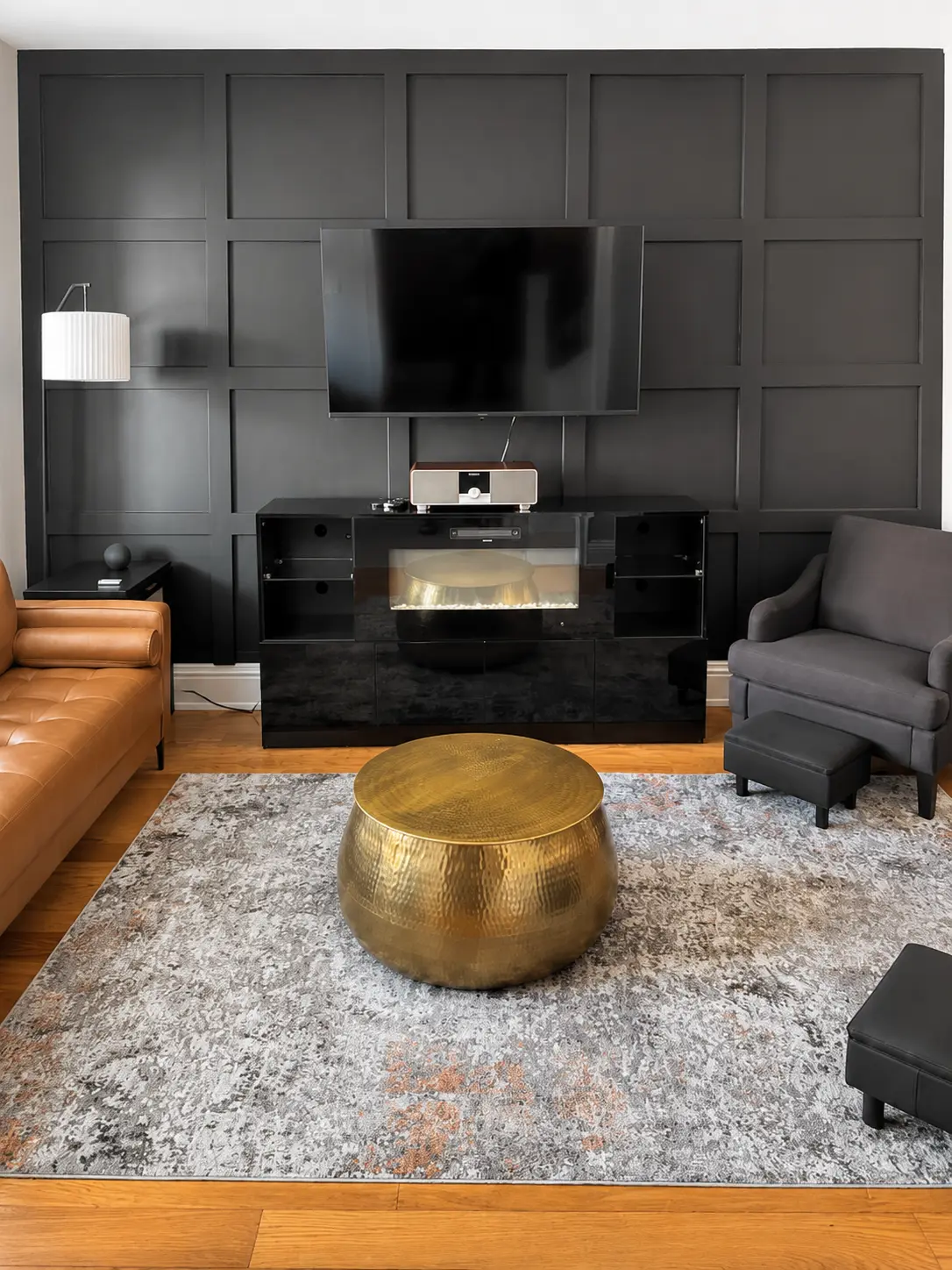 Living room with paneled accent wall, television, and seating
